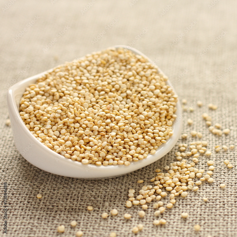Quinoa grain in white ceramic bowl on sackcloth background Quinoa grain in white ceramic bowl on sackcloth background