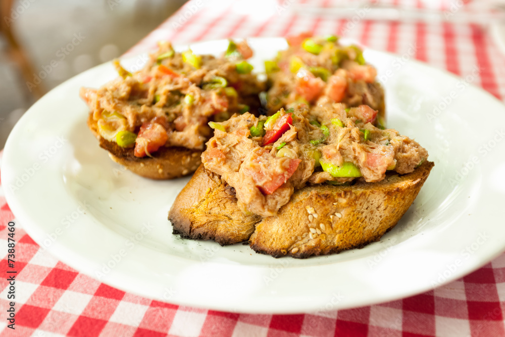 three bruschettas with tuna lying on plate at restaurant three bruschettas with tuna lying on plate at restaurant