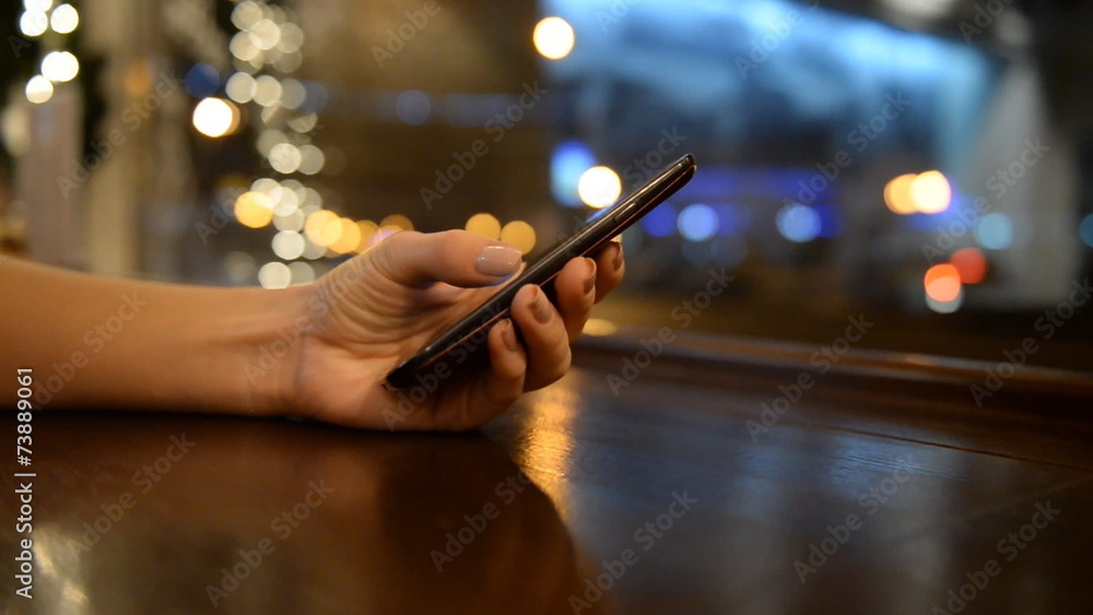 Close-up of female hands with the phone night restaurant cars Close-up of female hands with the phone night restaurant cars