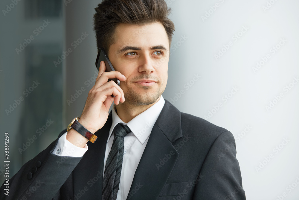 Businessman Talking on the Phone and Smiling Businessman Talking on the Phone and Smiling