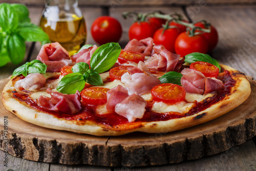 pizza with mozzarella and prosciutto, tomatoes