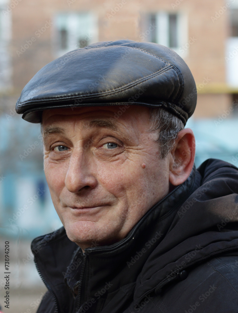 Пожилой мужчина в зимней одежде смотрит с улыбкой Пожилой мужчина в зимней одежде смотрит с улыбкой