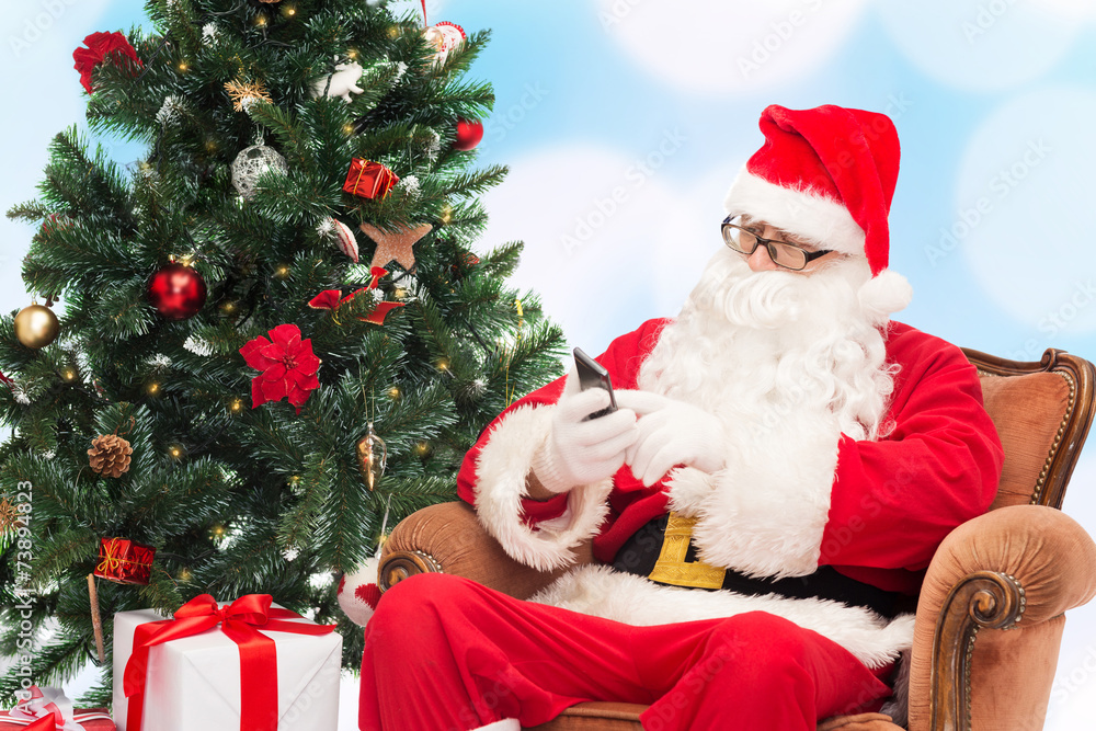 santa claus with smartphone and christmas tree santa claus with smartphone and christmas tree