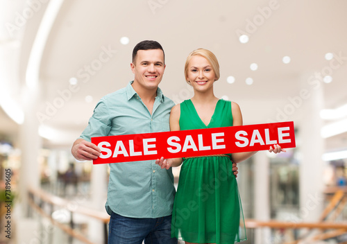 happy young couple with red shopping bags in mall