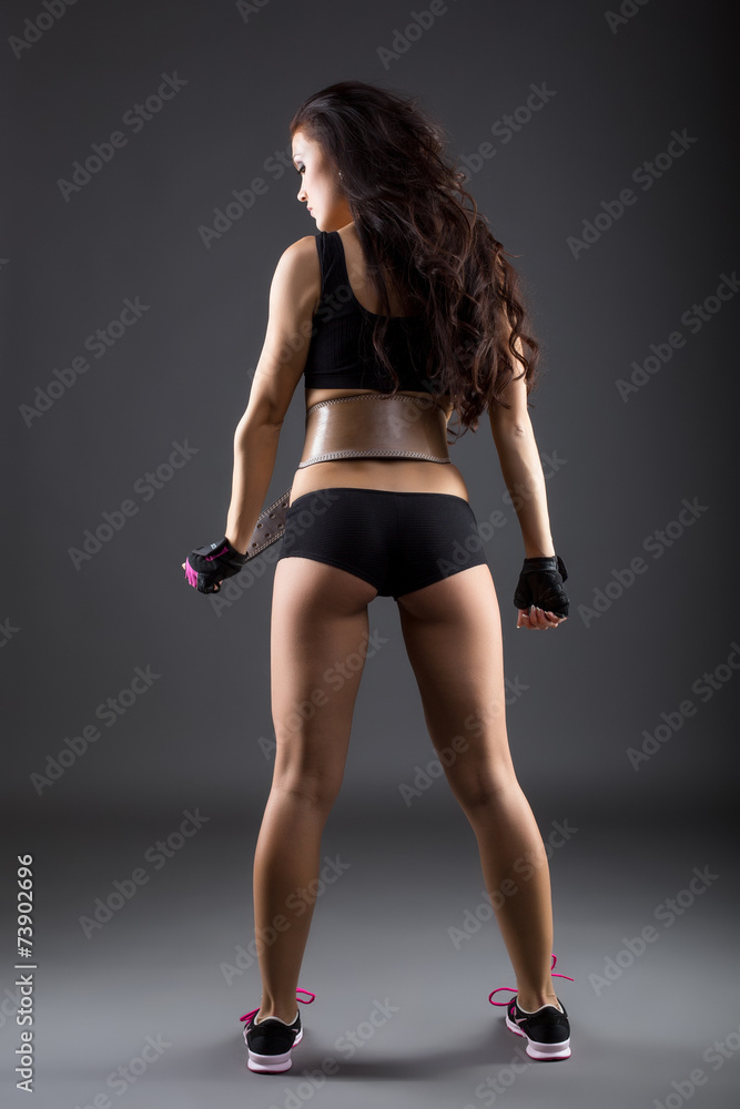 Rear view of sexy female athlete posing in studio