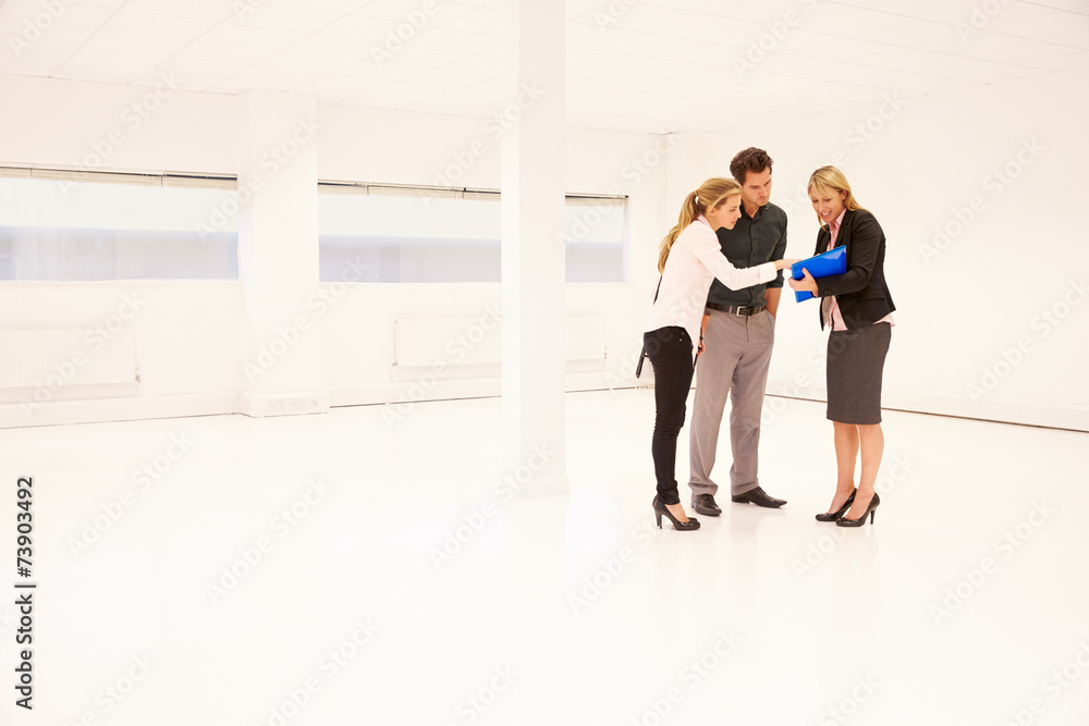 Estate Agent Showing Empty Office Space To Potential Clients