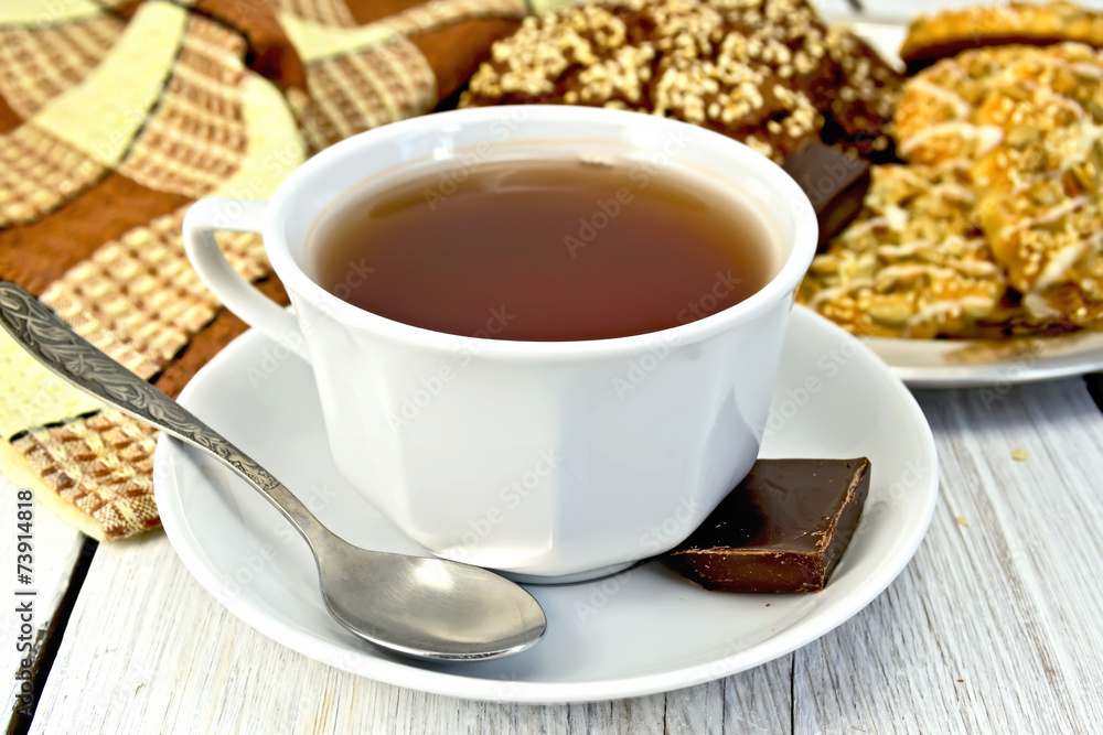 Tea in white cup with different cookies on light board Tea in white cup with different cookies on light board