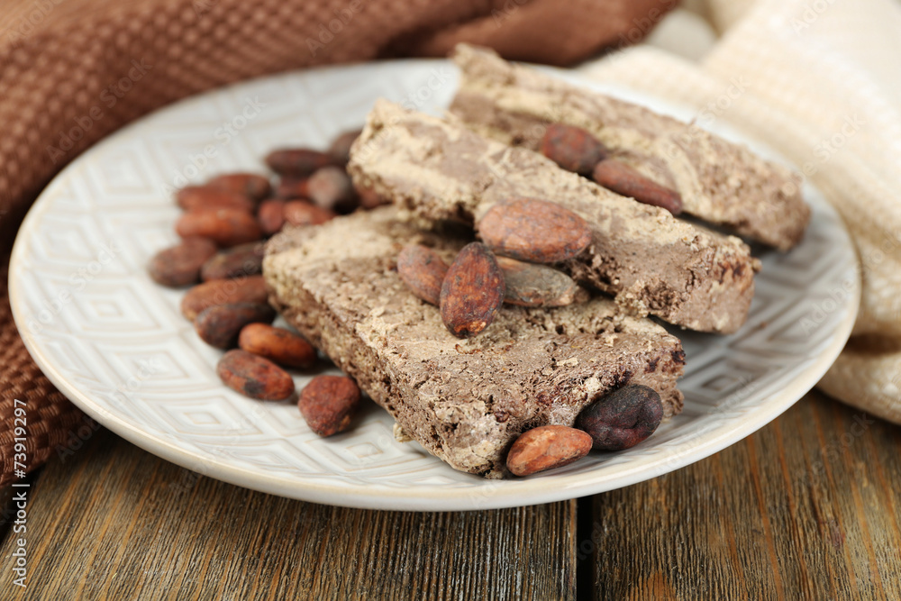 Sunflower halva with cocoa on plate, on wooden background Sunflower halva with cocoa on plate, on wooden background