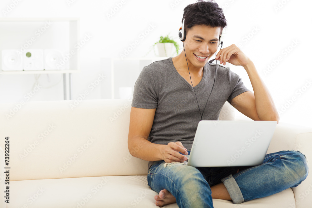 young Man sitting in sofa and using laptop young Man sitting in sofa and using laptop