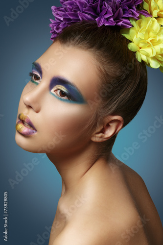Colorful makeup. Beautiful model with a bouquet of flowers in th