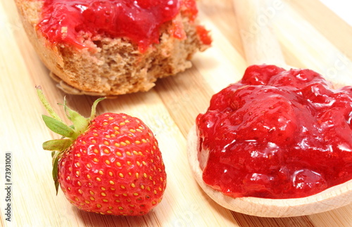 Fresh fruits and strawberry jam on wooden cutting board