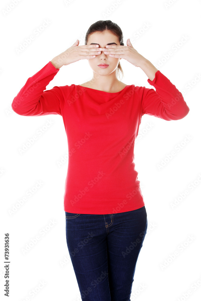 Brunette woman covering her face with both hands Brunette woman covering her face with both hands
