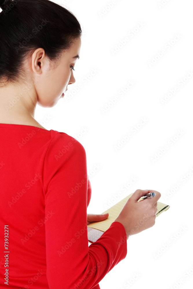 Woman writing notes and planning her schedule Woman writing notes and planning her schedule
