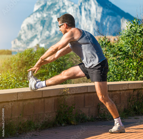 male athlete warming up before jogging