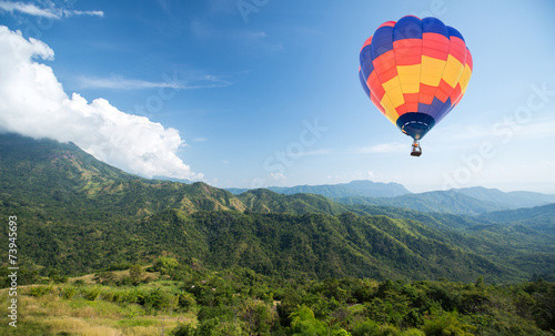 Hot air balloon over mountain and blue sky background