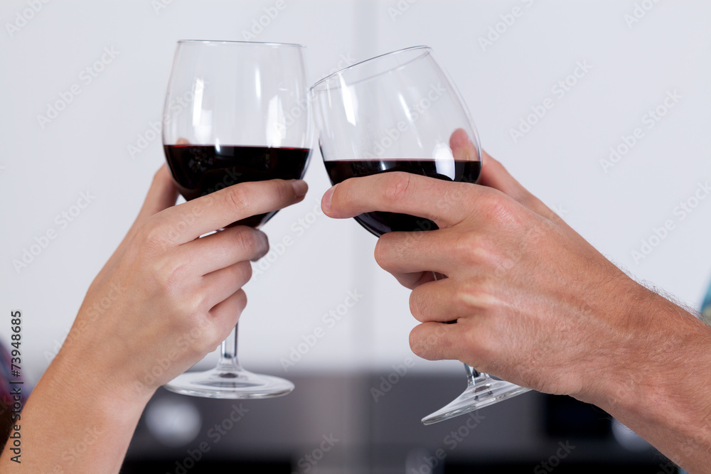 Couple's hands holding glasses of wine