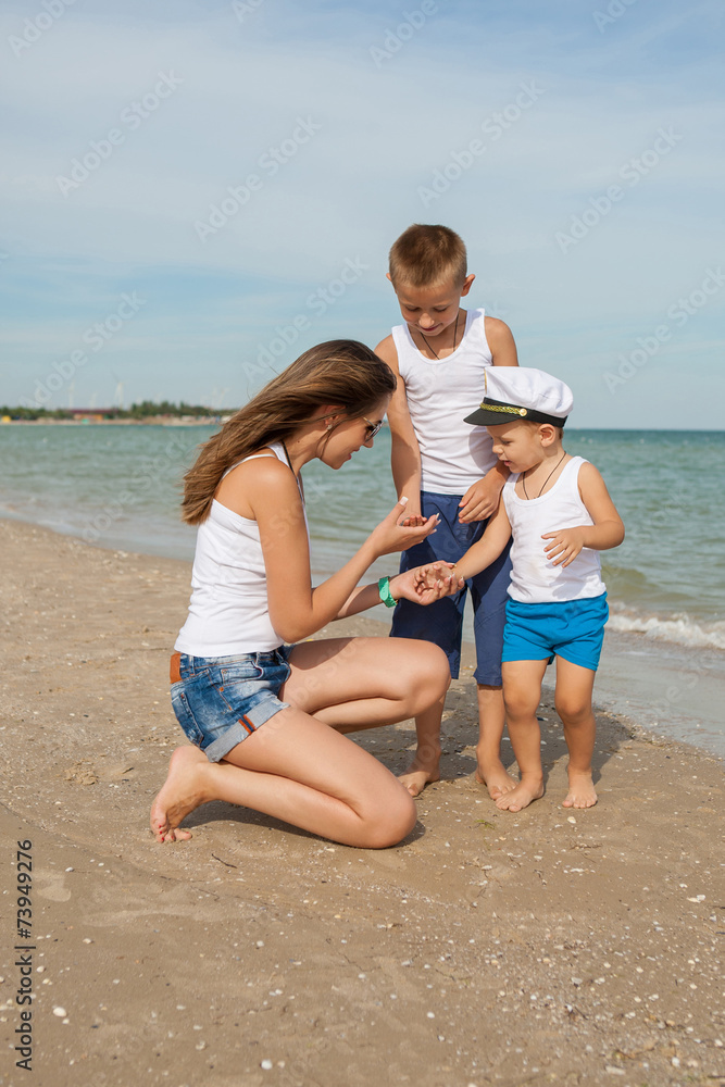 Mother and her two sons having fun on the beach Mother and her two sons having fun on the beach