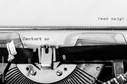 Typewriter; Contact us and Need help? text typed on a paper