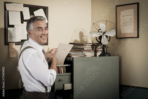 Smiling office worker searching for a file.