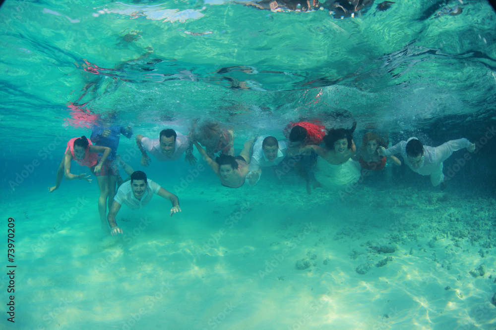 Group of young friends swim diving underwater Group of young friends swim diving underwater