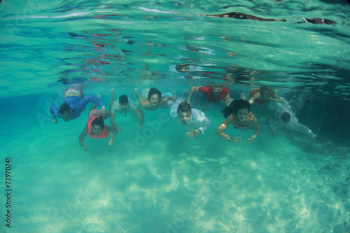 Group of young friends swim diving underwater