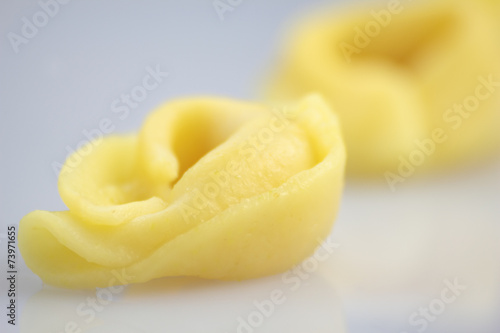 Two tortellini on bright background.