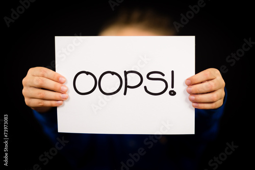 Child holding OOPS sign
