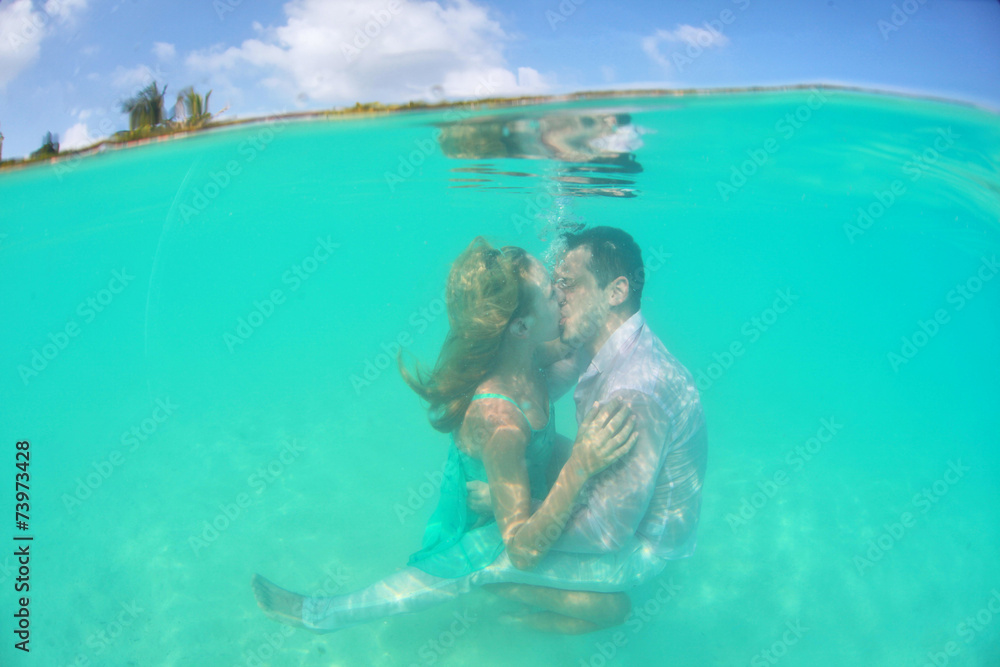 Beautiful underwater kiss of loving couple lovely
