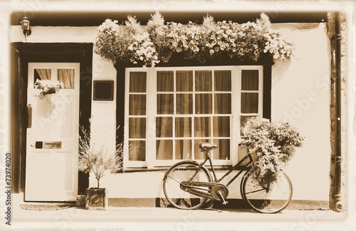 Vintage theme with bicycle against old cottage #73974020