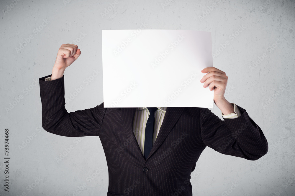 Businessman holding in front of his head a paper with copy space Businessman holding in front of his head a paper with copy space