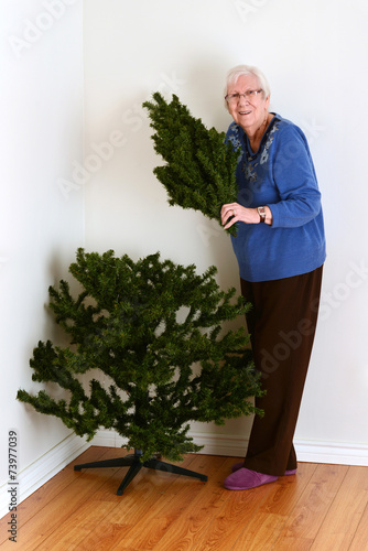senior woman with fake christmas tree