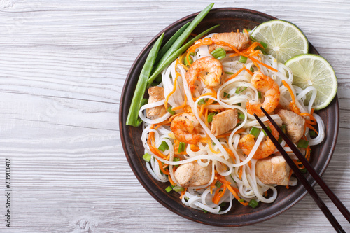 rice noodles with chicken, shrimp and vegetables top view photo