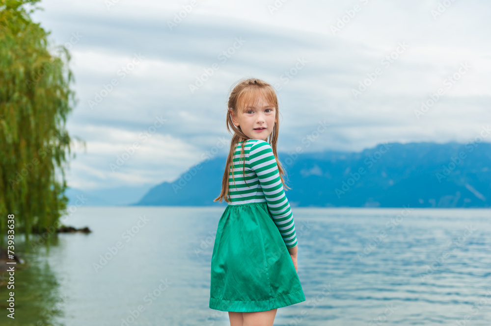 Cute little girl playing next to beautiful lake Cute little girl playing next to beautiful lake