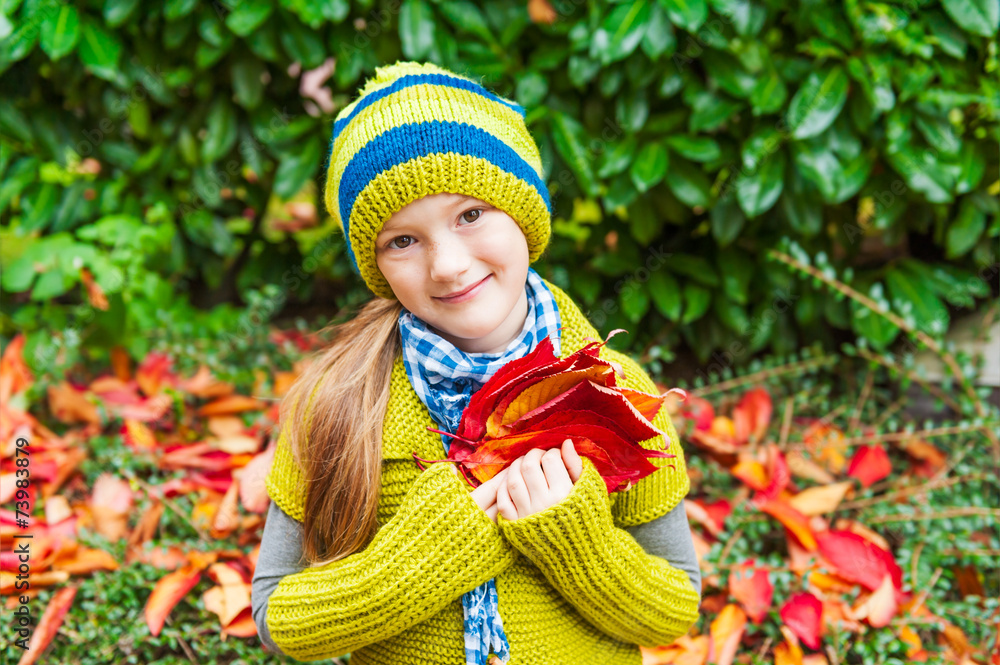 Autumn portrait of a cute little girl playing outdoors