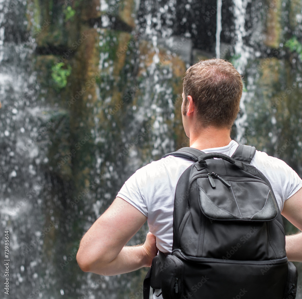 Tourist with backpack near waterfall. Space for your text. Tourist with backpack near waterfall. Space for your text.