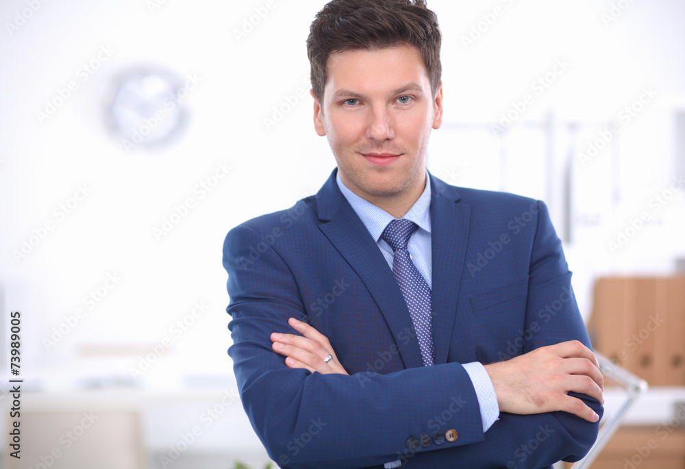Business man or manager standing against his desk at office with Business man or manager standing against his desk at office with