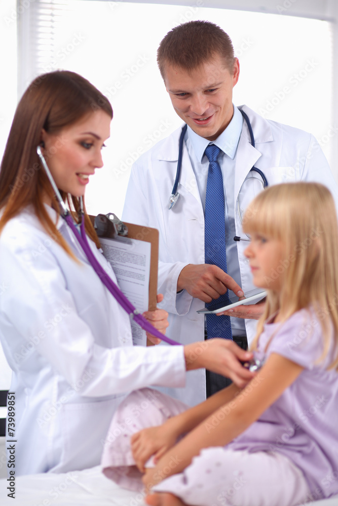 Female doctor examining child with stethoscope at surgery