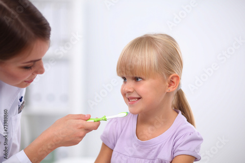 Dentist and little girl in the dentist office.