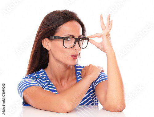Pretty hispanic holding glasses looking at you