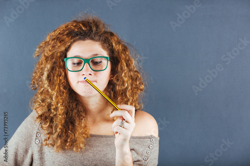 Pensive Curly Young Woman on Gray Background