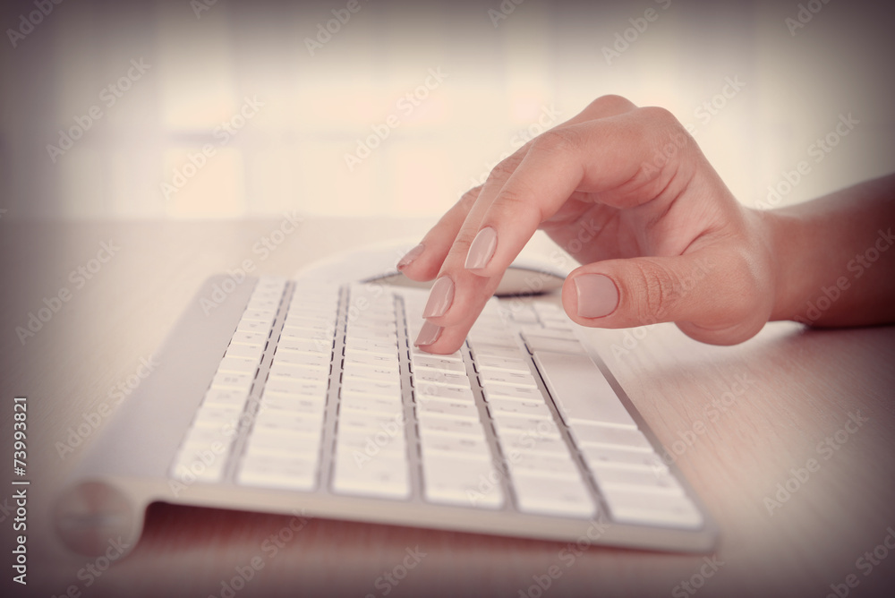 Female hands typing on keyboard on light background Female hands typing on keyboard on light background