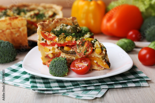 Piece of Vegetable pie with broccoli, peas, tomatoes and cheese