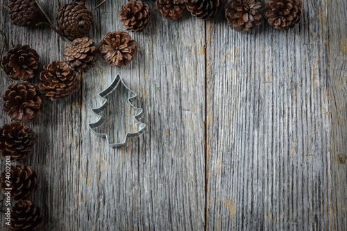 Pine Cones and Christmas Tree on a Rustic Wood Background