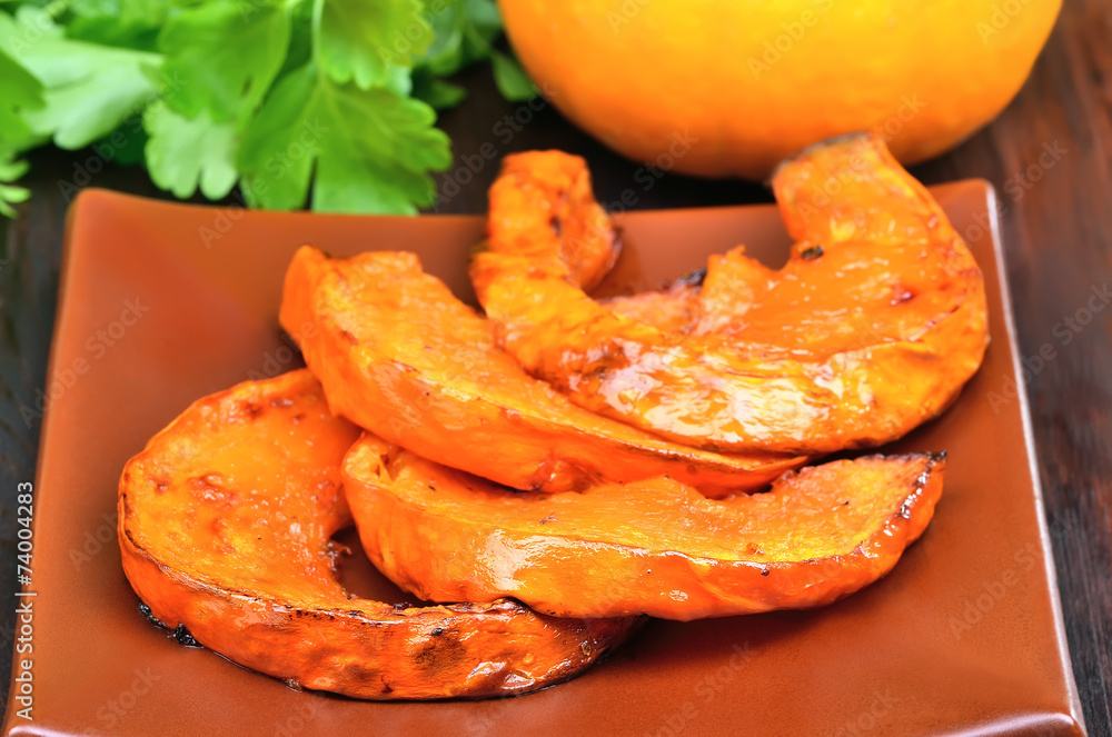 Baked pieces of pumpkin on plate Baked pieces of pumpkin on plate