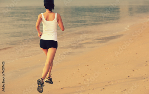 young asian woman running on beach