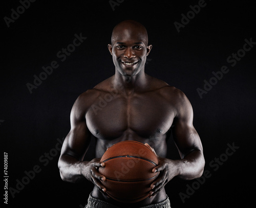 Shirtless basketball player looking at camera smiling. © Jacob Lund