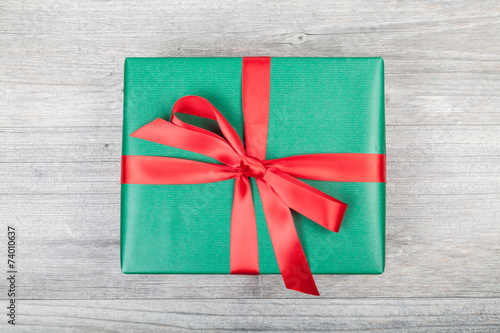 grünes weihnachtsgeschenk auf holzplatte