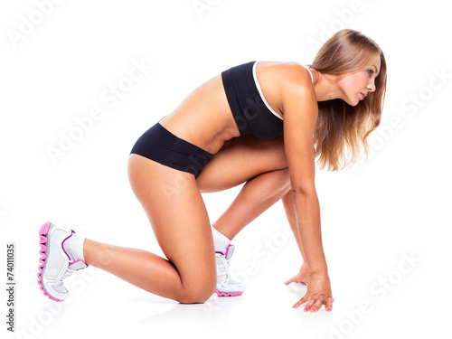 Young sports girl does exercises on a white