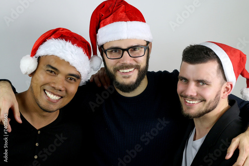 three friends smiling for Christmas on a gray background