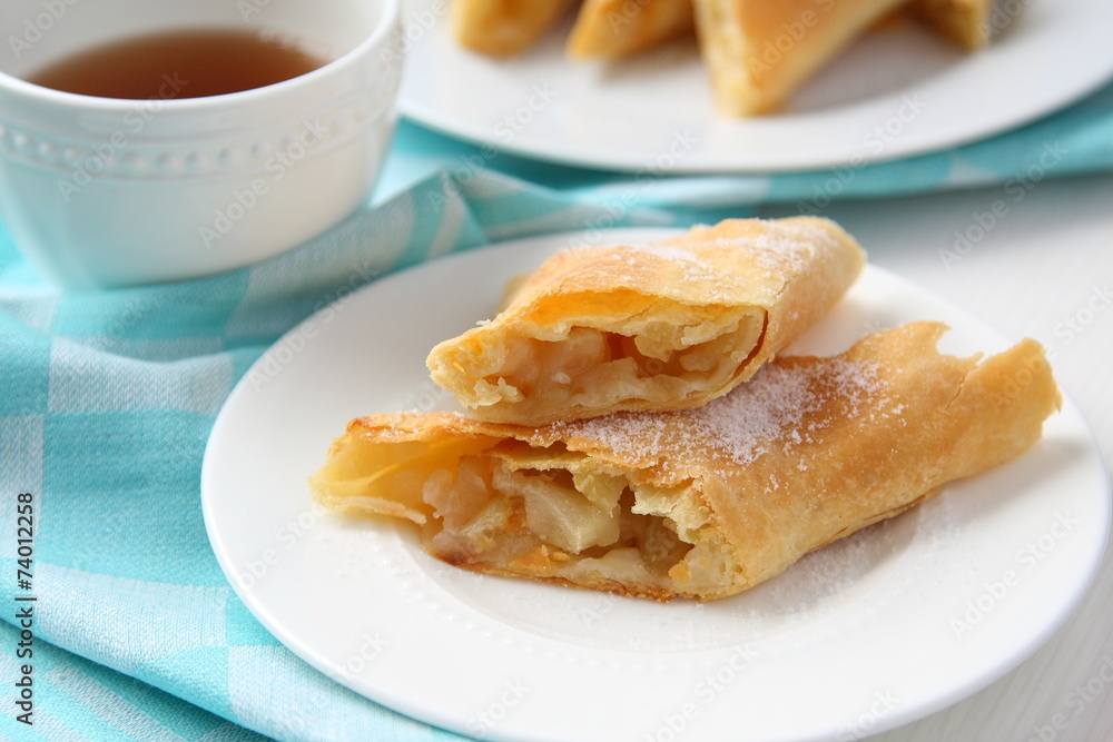 Fresh Apfelstrudel on a plate with blue towel Fresh Apfelstrudel on a plate with blue towel